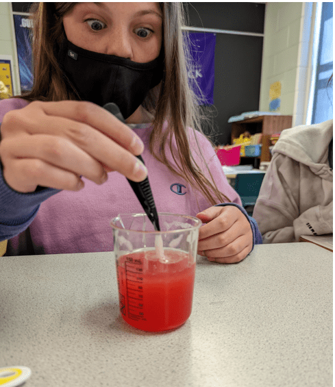 Student With a Chemical Beaker Handling Slimy Red Substance