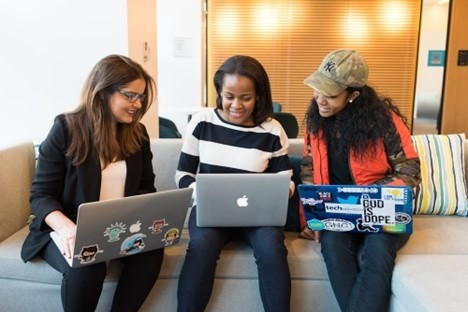 Three Students Sit Together in a Sofa with Laptops on their Laps