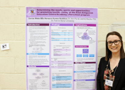 Student standing with their project