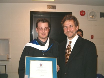 Student showing his diploma, next to a man