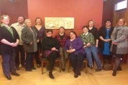 A group of people standing and sitting in a room