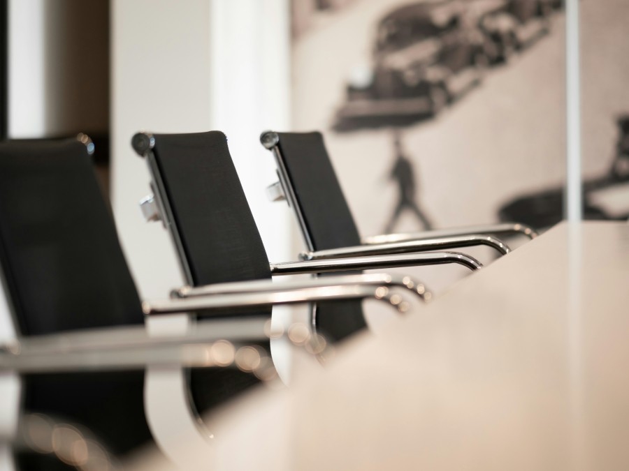Conference room table with black office chairs around it.