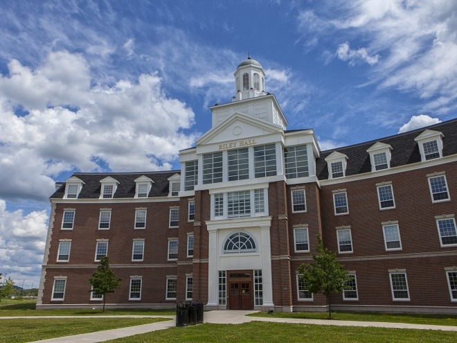 Exterior view of Riley Hall on a sunny day with a few clouds in the sky.